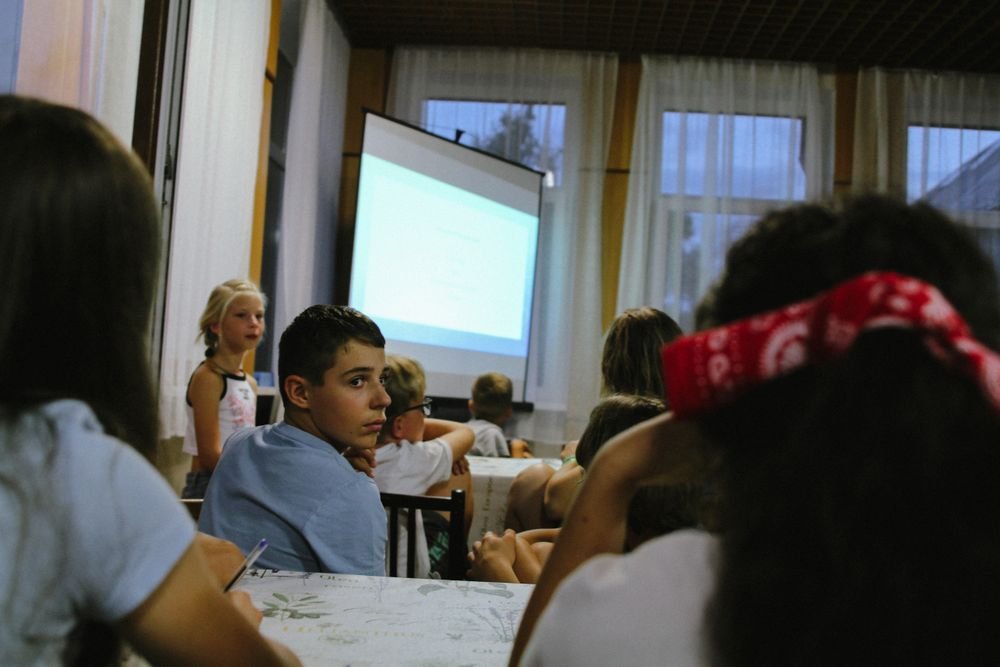 Children seated together during an indoor presentation