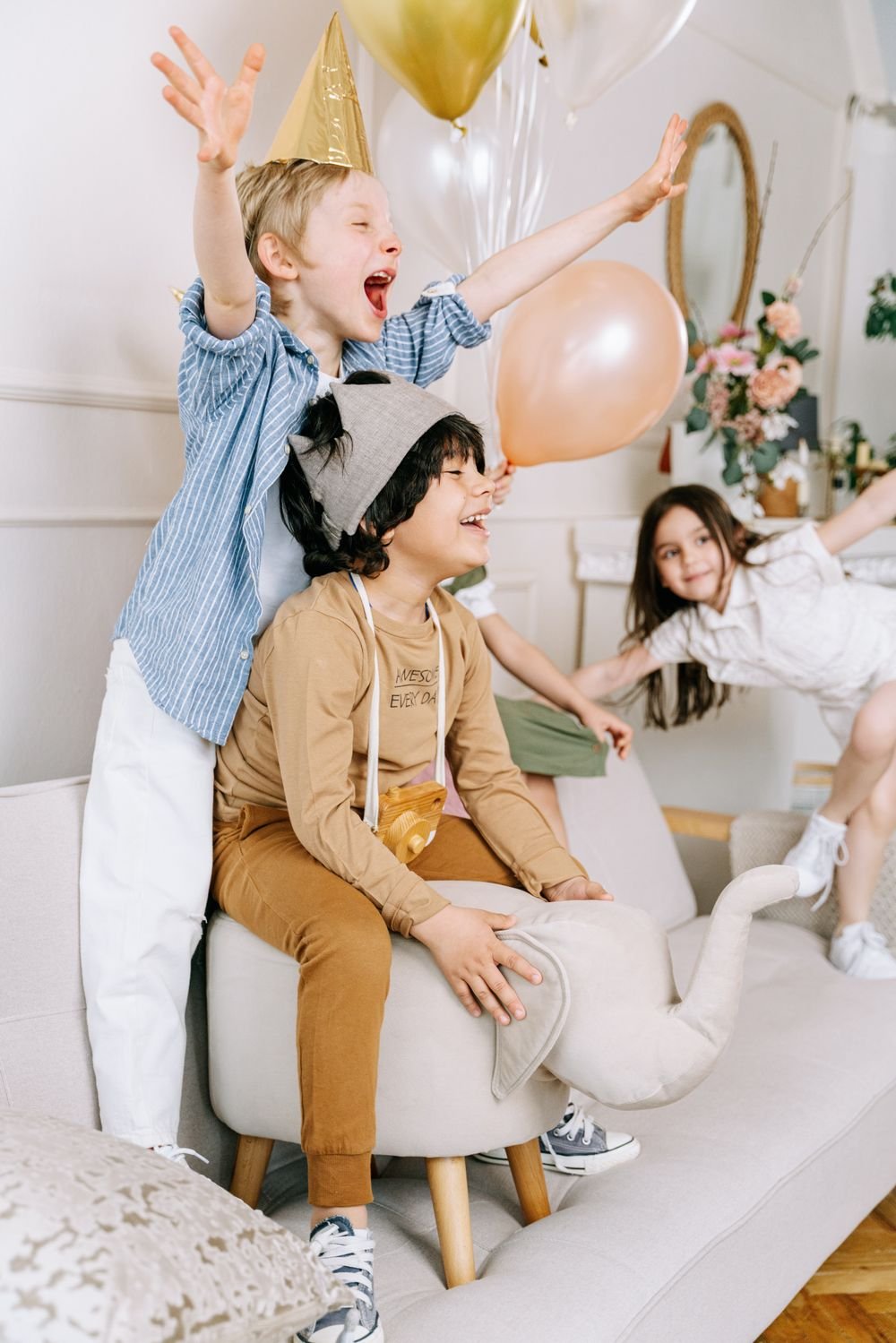 Children laughing and playing with balloons at a birthday party
