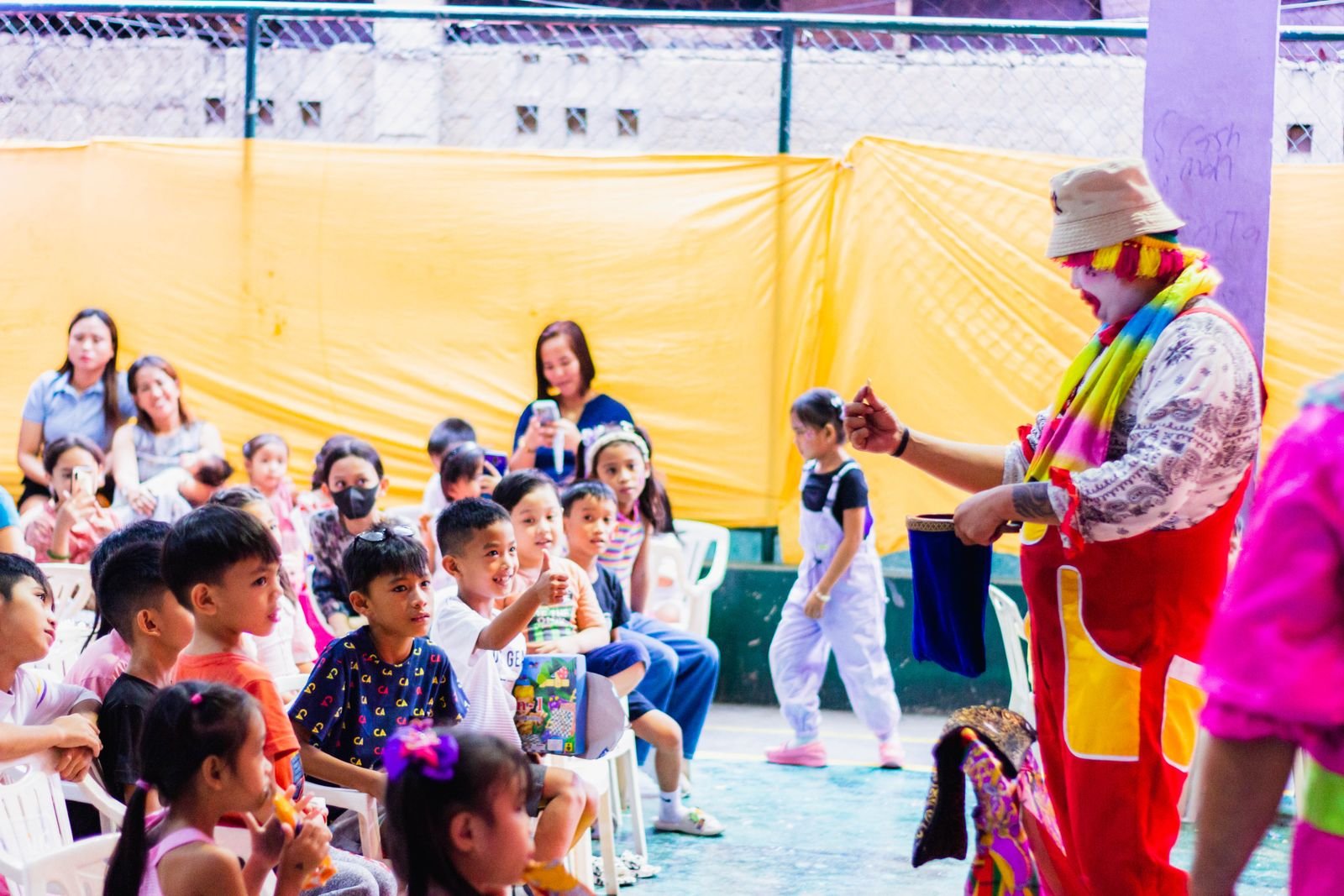Costumed entertainer performing for a group of excited children at an outdoor party